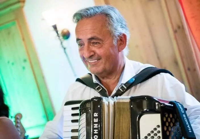 Toni von Coco Loco mit Akkordeon und Mikrofon bei einem Auftritt